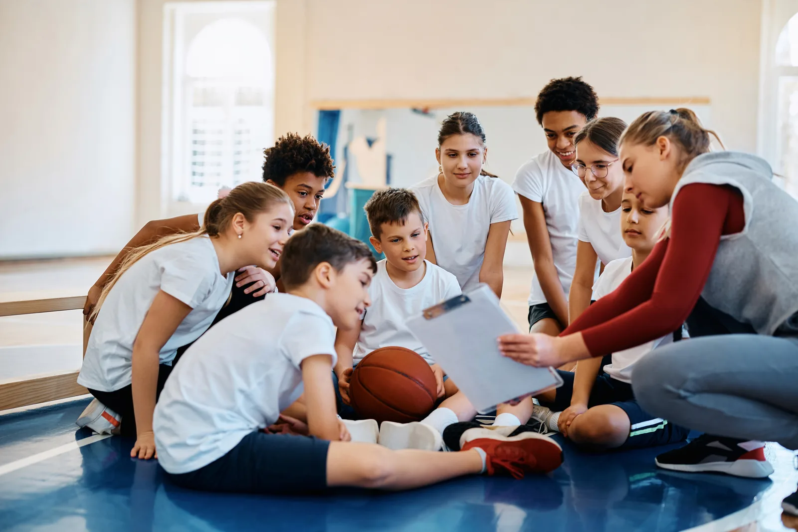 Coach explains strategy to youth team, reflecting Graphic House's guidance.