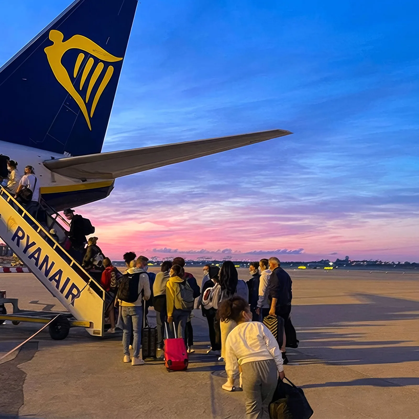 Travelers board a Ryanair plane at sunset, symbolizing reach for website design.